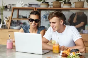 wesoła i uśmiechnięta para spoglądająca na laptopa